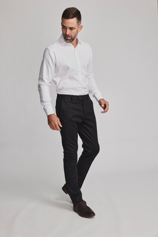 A man with short dark hair and a beard wears the Barkers Mexted Texture Shirt, black dress pants, and brown shoes. He stands against a plain light background, looking down to his left.