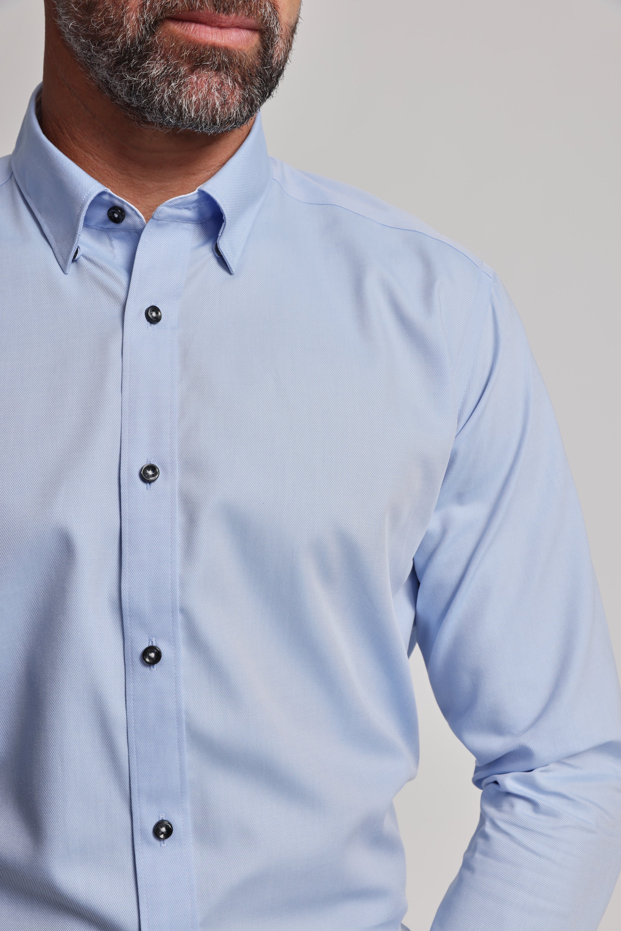 A bearded man wears the Barkers Verona Shirt, a light blue tailored fit business shirt with long sleeves, shown from the chest up against a plain background.