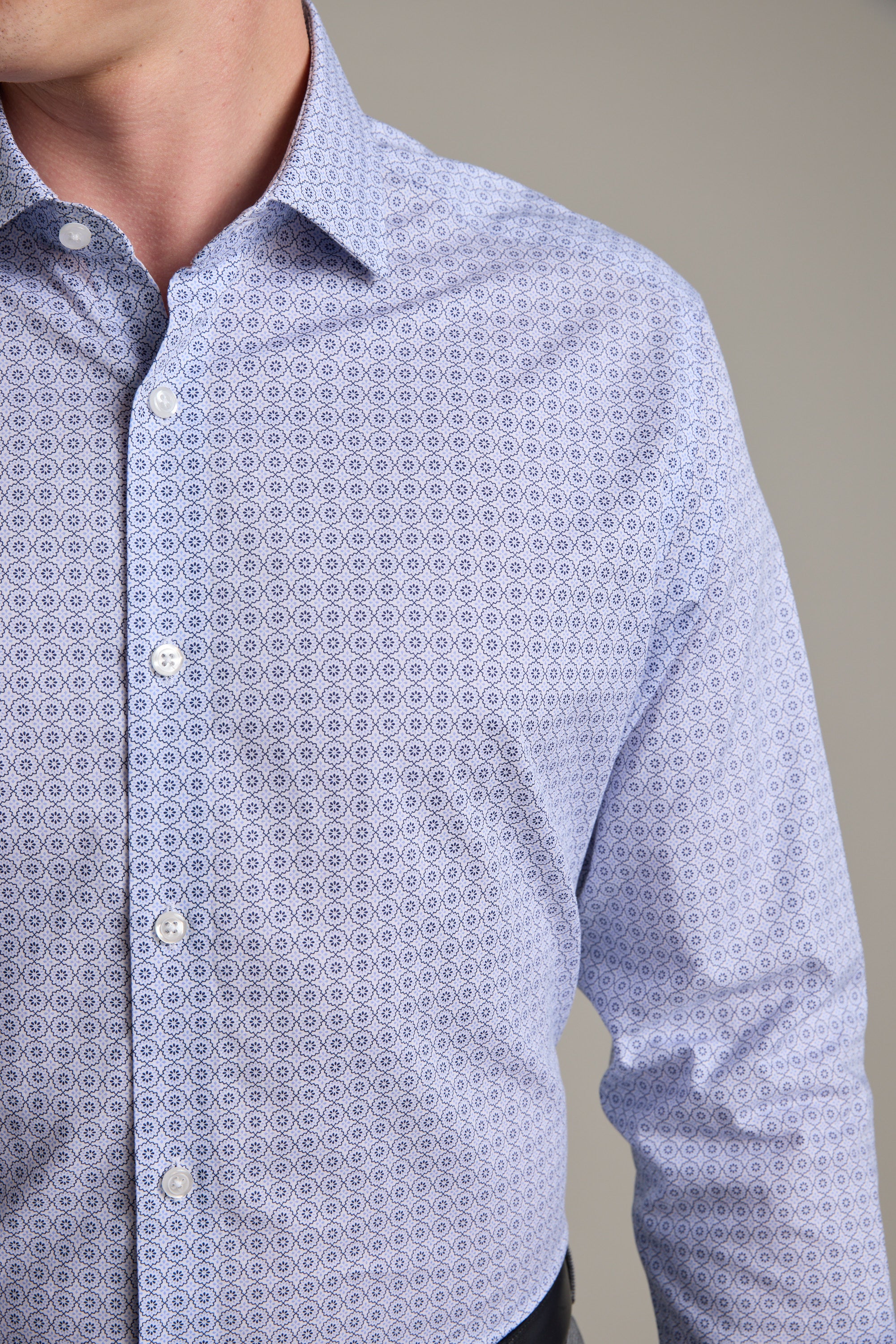 A person wearing the Barkers Seton Print Business Shirt in light blue, featuring a small geometric pattern, is shown from shoulders to waist against a plain background.