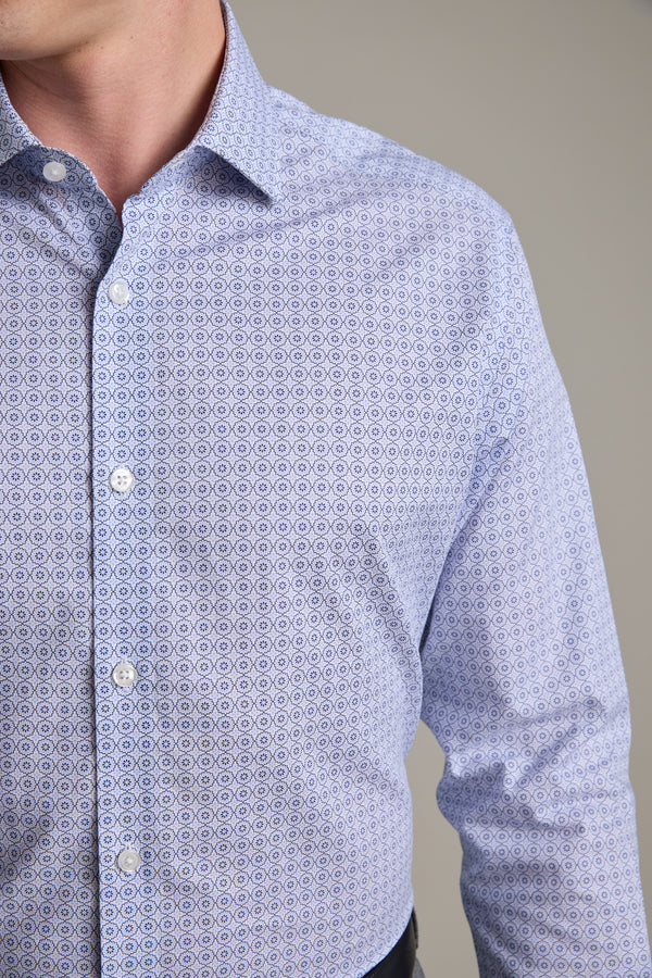 A person wearing the Barkers Seton Print Business Shirt in light blue, featuring a small geometric pattern, is shown from shoulders to waist against a plain background.