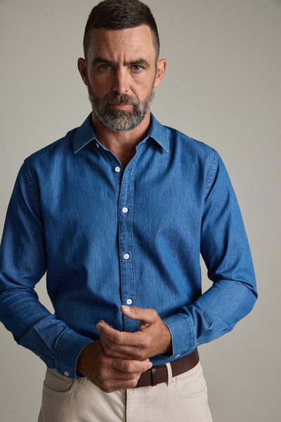 Man with a beard wears Barkers' Wyatt Denim Business Shirt and beige pants against plain background.