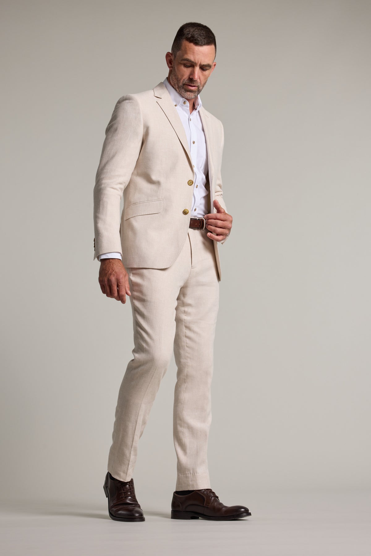 Man in Barkers Thompson Textured Linen Pant, looking down against a plain background.