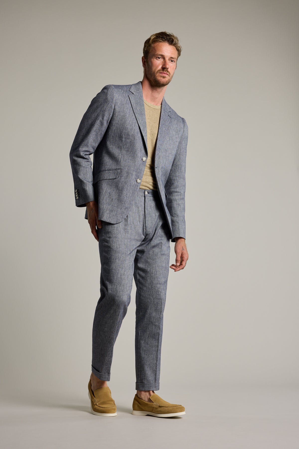 Man in Barkers Paden Twill Pant, beige shirt, and tan shoes against a plain background.