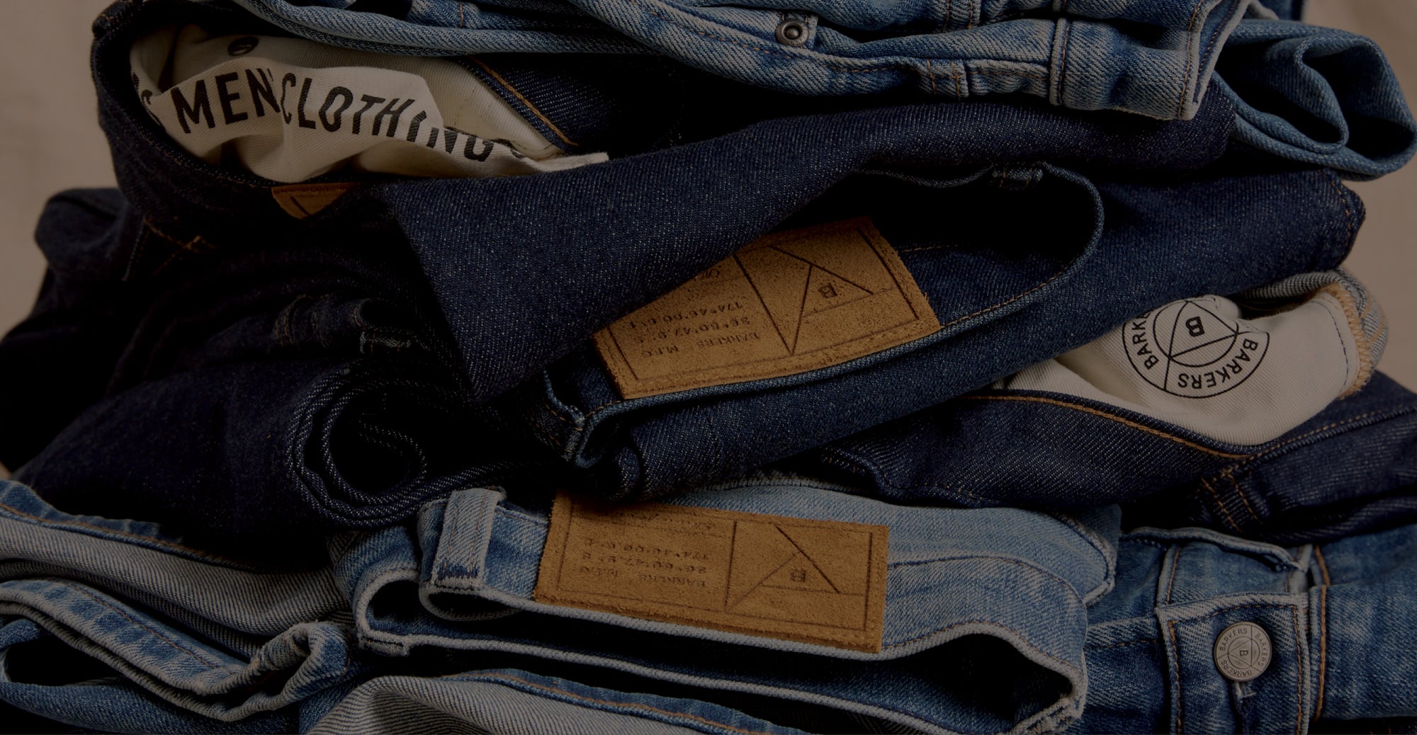 A stack of folded NZ blue jeans with visible labels and tags.