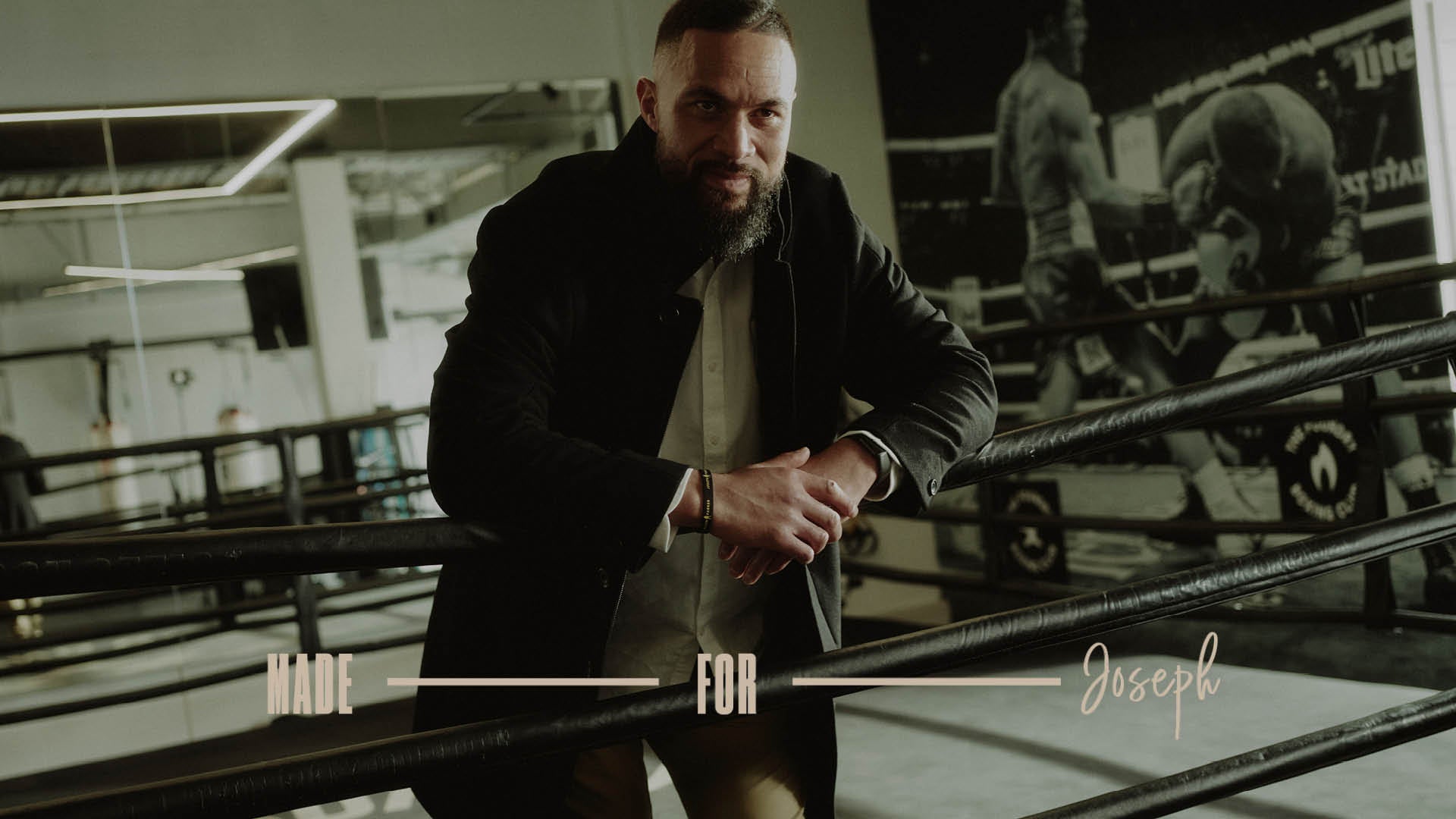Man in a coat leaning on boxing ring ropes with NZ Made for Joseph text at the bottom.