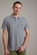 A man wears a Barkers Regent Pique Polo, standing against a plain, light background.