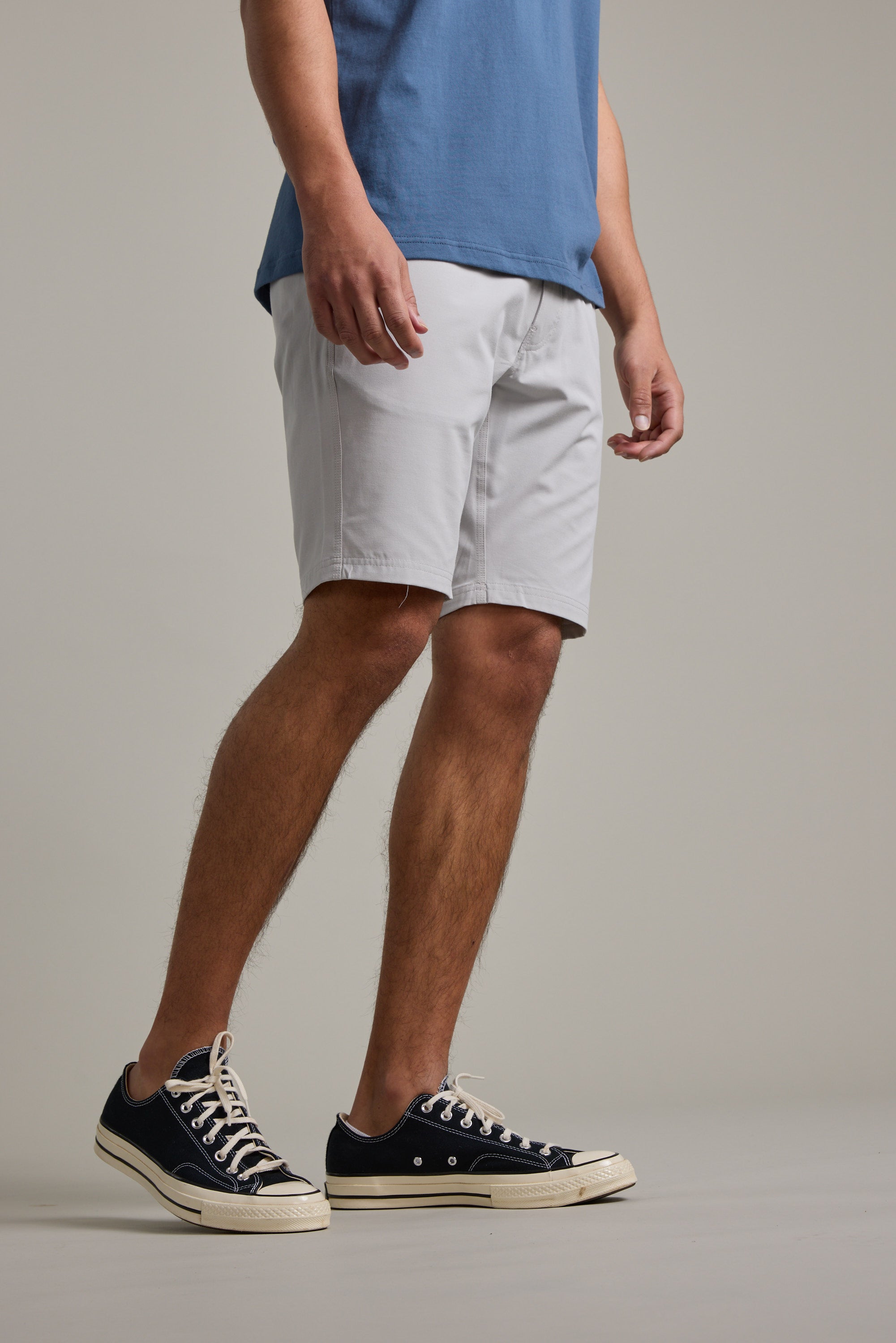 The lower half of a person is shown against a light gray background, wearing Barkers Hutchinson Walkshort in light gray and black low-top sneakers with white soles.