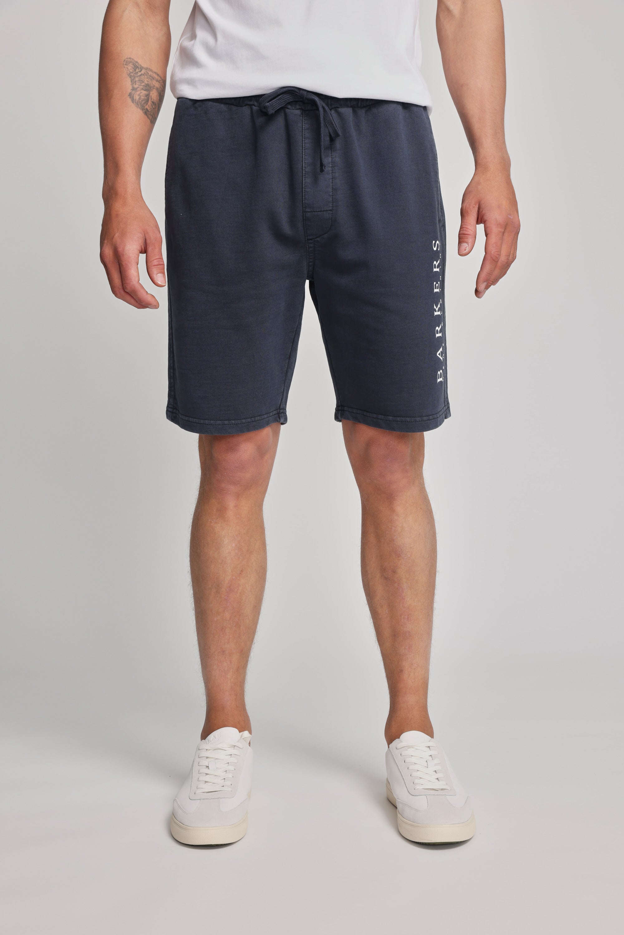 A man wearing Barkers Organic Classic Print Track Shorts and white shoes.