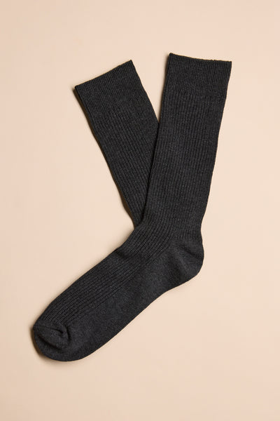 A pair of Barkers Business Socks in dark gray, featuring a ribbed design and responsibly sourced cotton, are laid flat on a light beige background with one sock slightly overlapping the other.