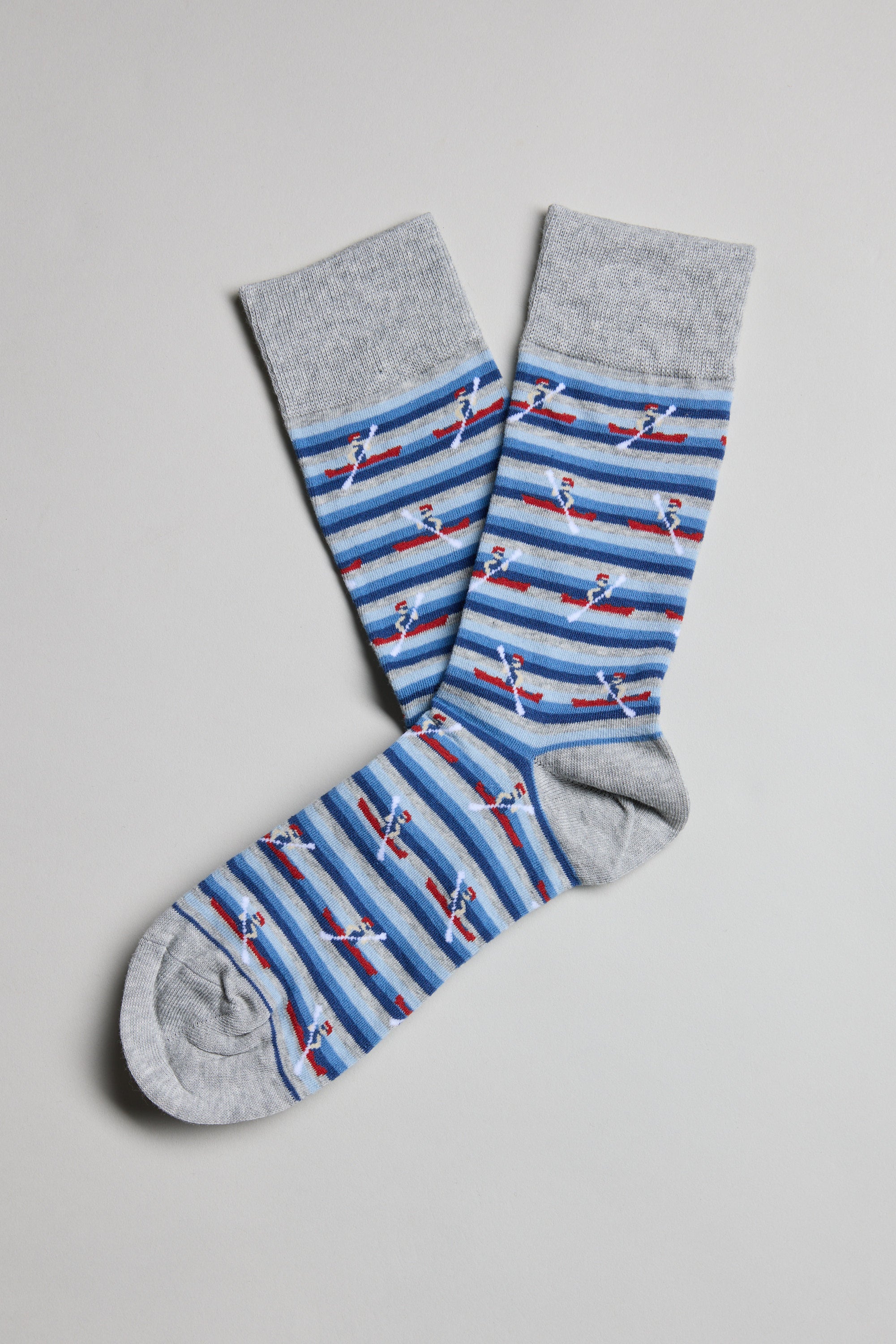 A pair of Barkers Ronnie Rower Socks in gray, featuring blue and gray stripes with small red and white boat patterns, laid flat on a light gray background—comfortable and ideal for everyday wear.