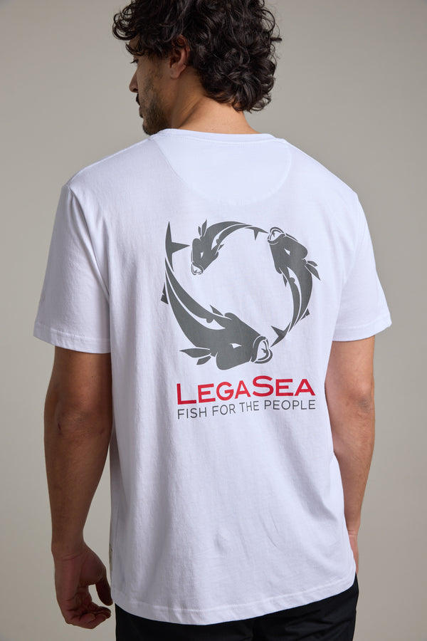 A man wears the Legasea Brand Tee, made from organic cotton, with a circular fish graphic and "LEGASea FISH FOR THE PEOPLE" in red and gray on the back as he faces away, clearly displaying the Legasea design.