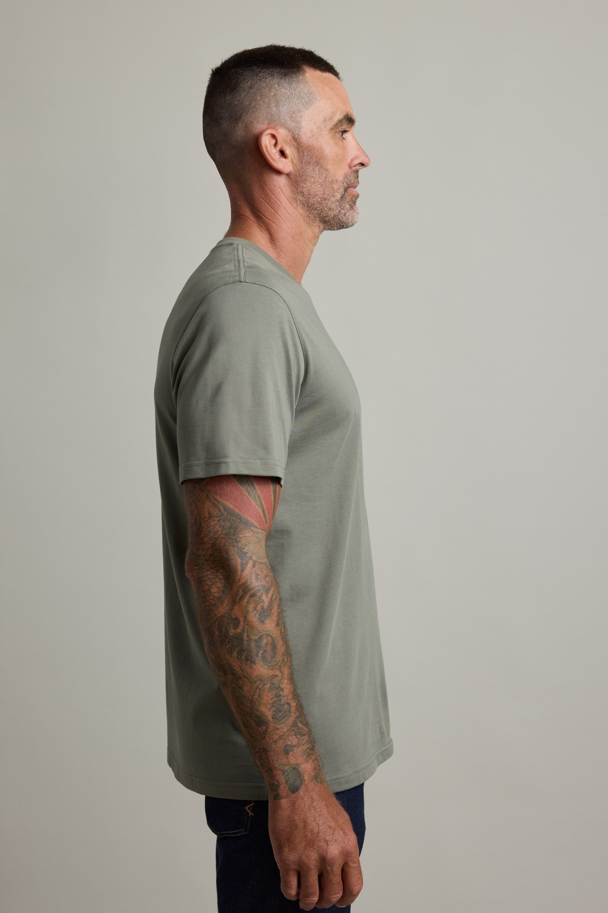 Man in Barkers Good Earth Cotton Essential Tee, traceable cotton, gray, stands in profile.