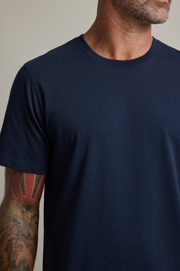Man wearing Barkers Good Earth Cotton Essential Tee, colorful tattoo, facing slightly right.