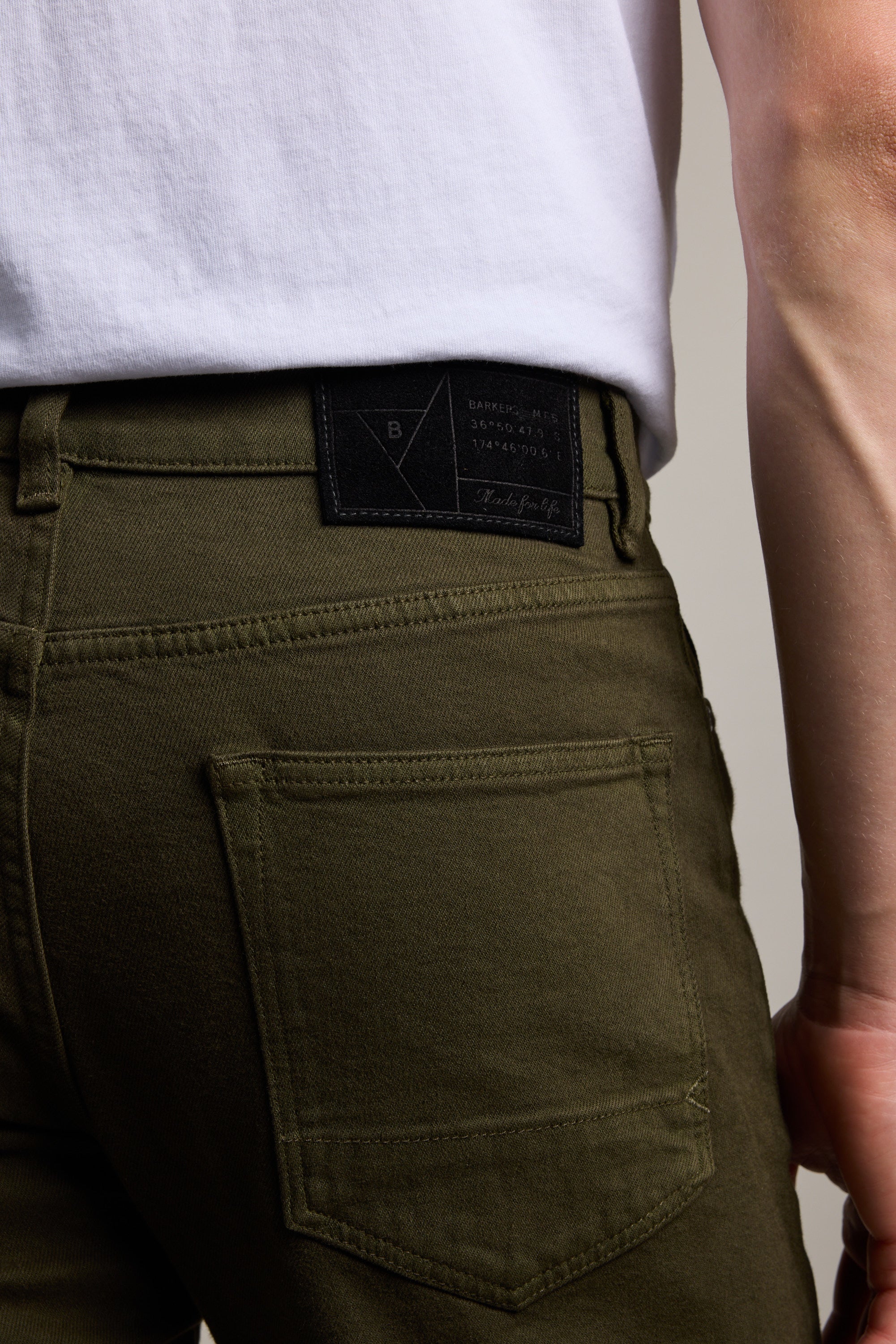 Person wearing Barkers Wanderer Straight Coloured Jean in olive green and a white shirt, back view.