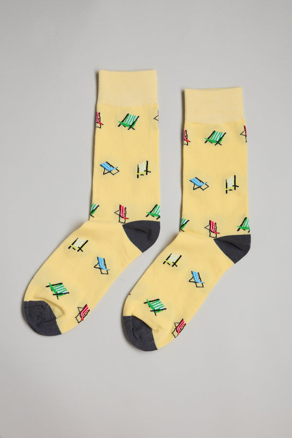 A pair of Barkers Deck Chair Socks in yellow with gray toes and heels, featuring colorful abstract birds—an ideal Christmas gift or Secret Santa surprise, shown on a plain light gray background.