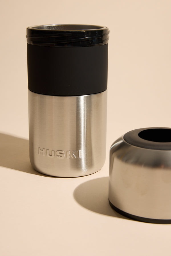 The Huski Wine Cooler by Huski is a stainless steel insulated cup with a black lid and detachable base, designed to keep wine cold for hours—ideal for enjoying your favorite drink anywhere.