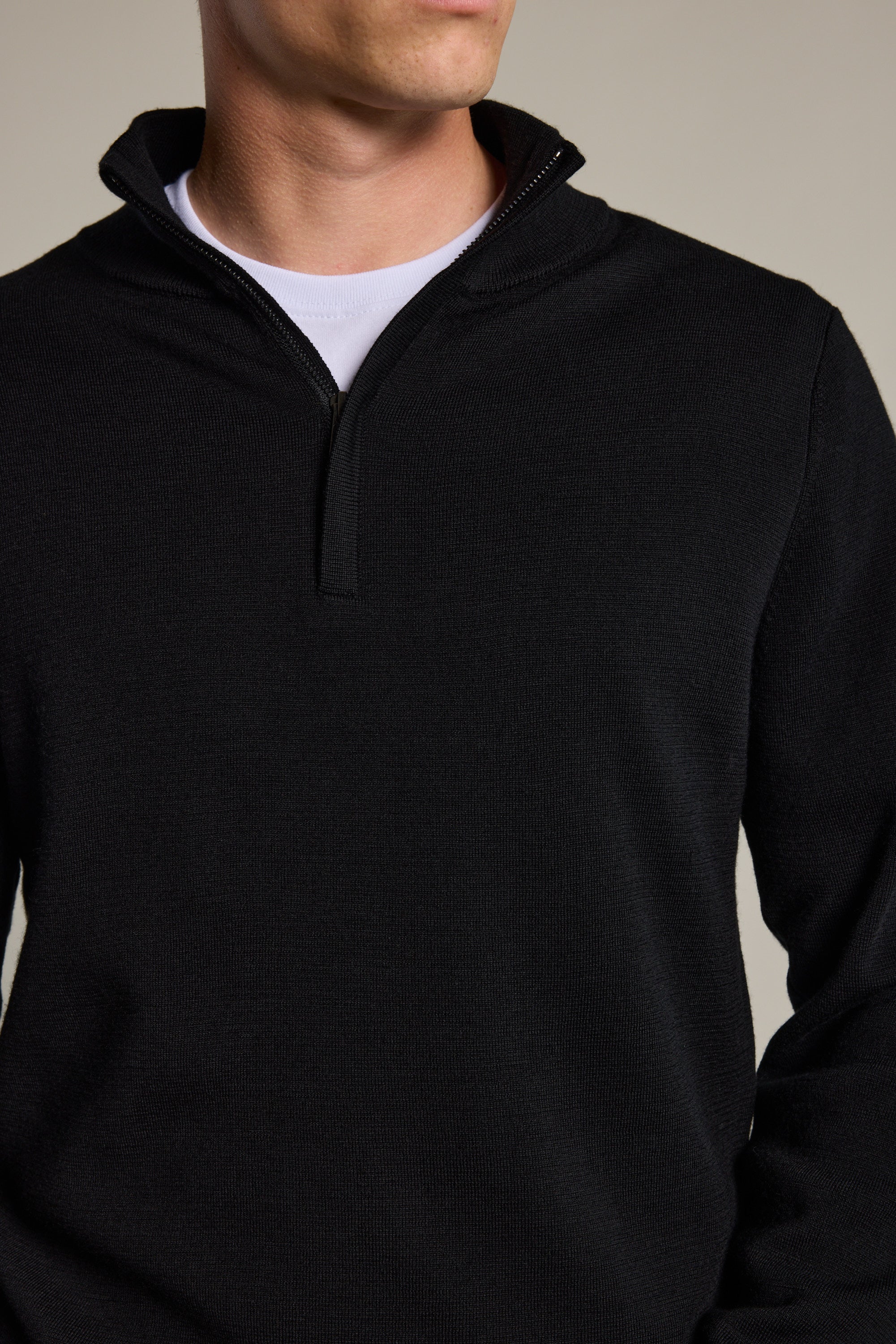 A person wears the Barkers Brandon ZQRX Merino 1/4 Zip in black over a white crew-neck shirt, shown from shoulders to above the waist against a neutral background—ideal for cold-weather layering.