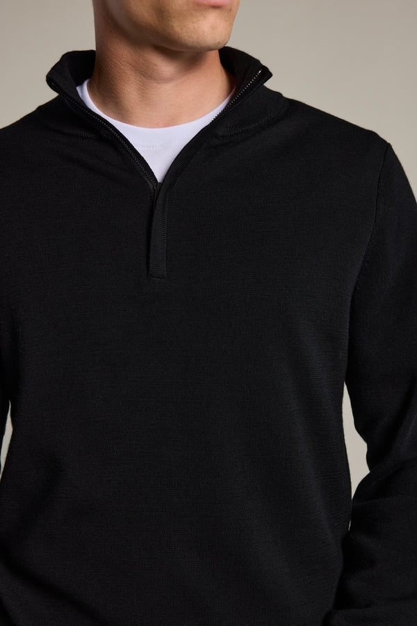 A person wears the Barkers Brandon ZQRX Merino 1/4 Zip in black over a white crew-neck shirt, shown from shoulders to above the waist against a neutral background—ideal for cold-weather layering.