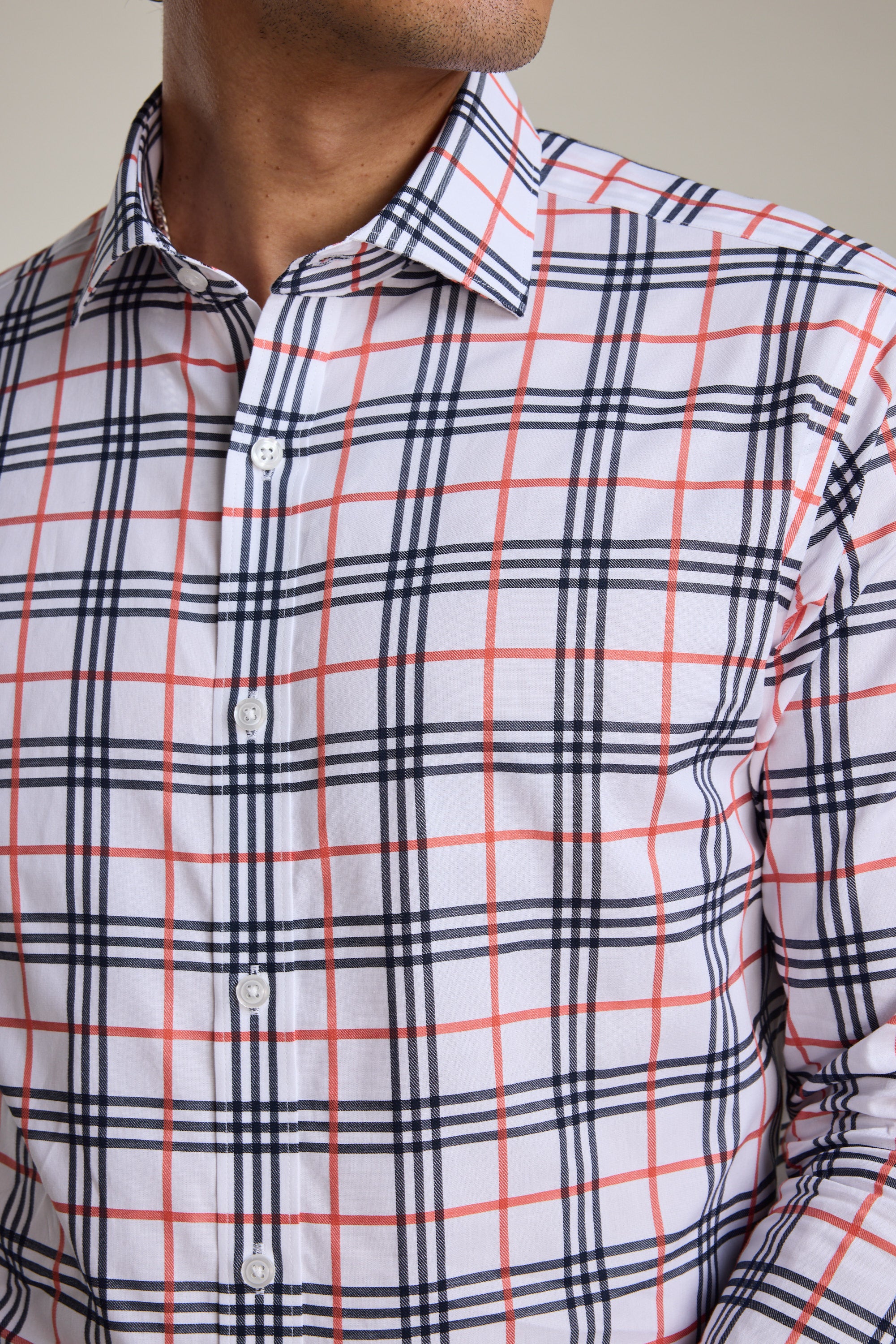 A man wears the Barkers Wilma French Cuff Business Shirt, a wrinkle-free white shirt with a red and navy blue plaid pattern. Only his lower face and upper torso are shown.