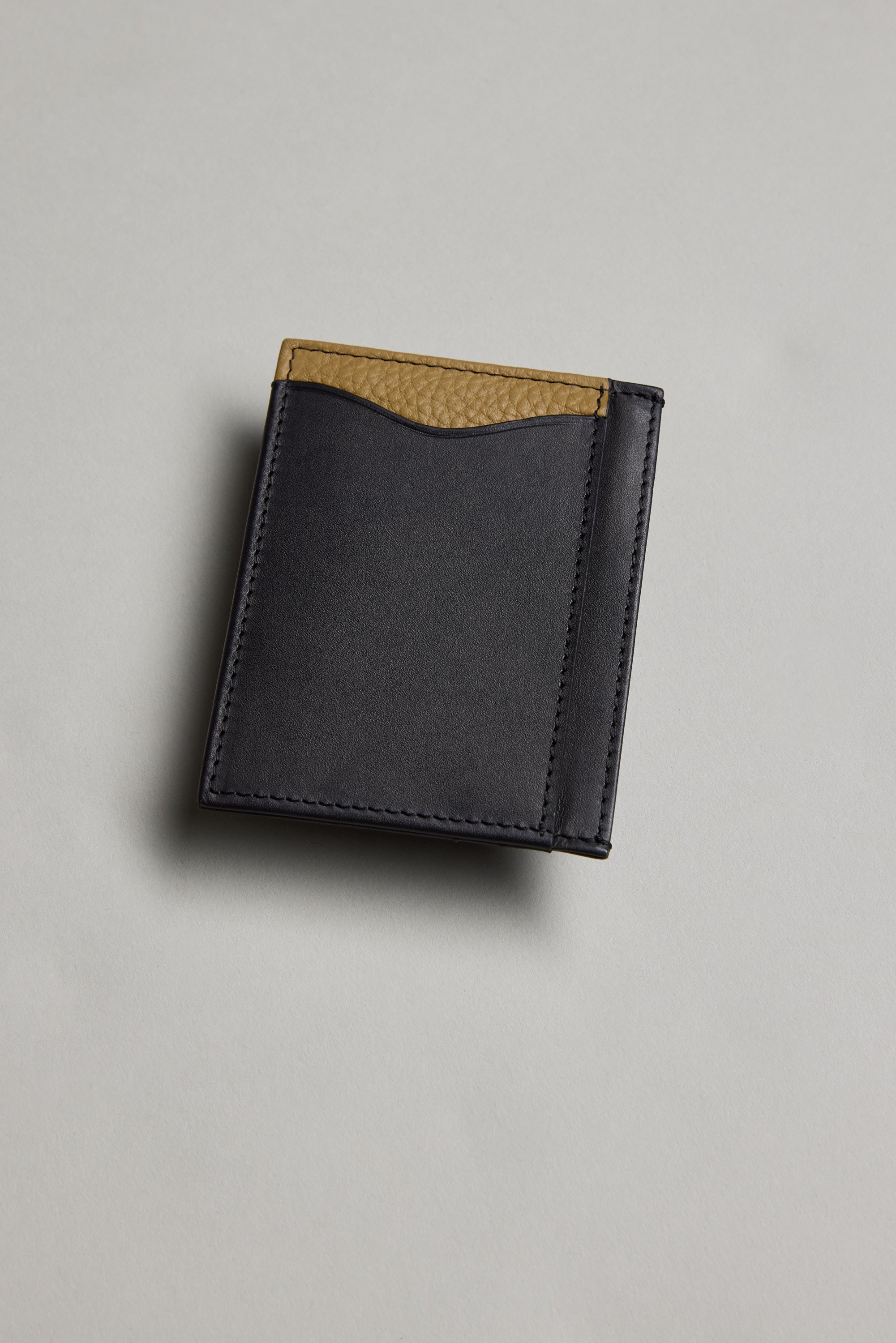 The Barkers Taylor Leather Card Wallet features sustainable black leather with a tan textured accent along the top edge, shown on a light gray surface.
