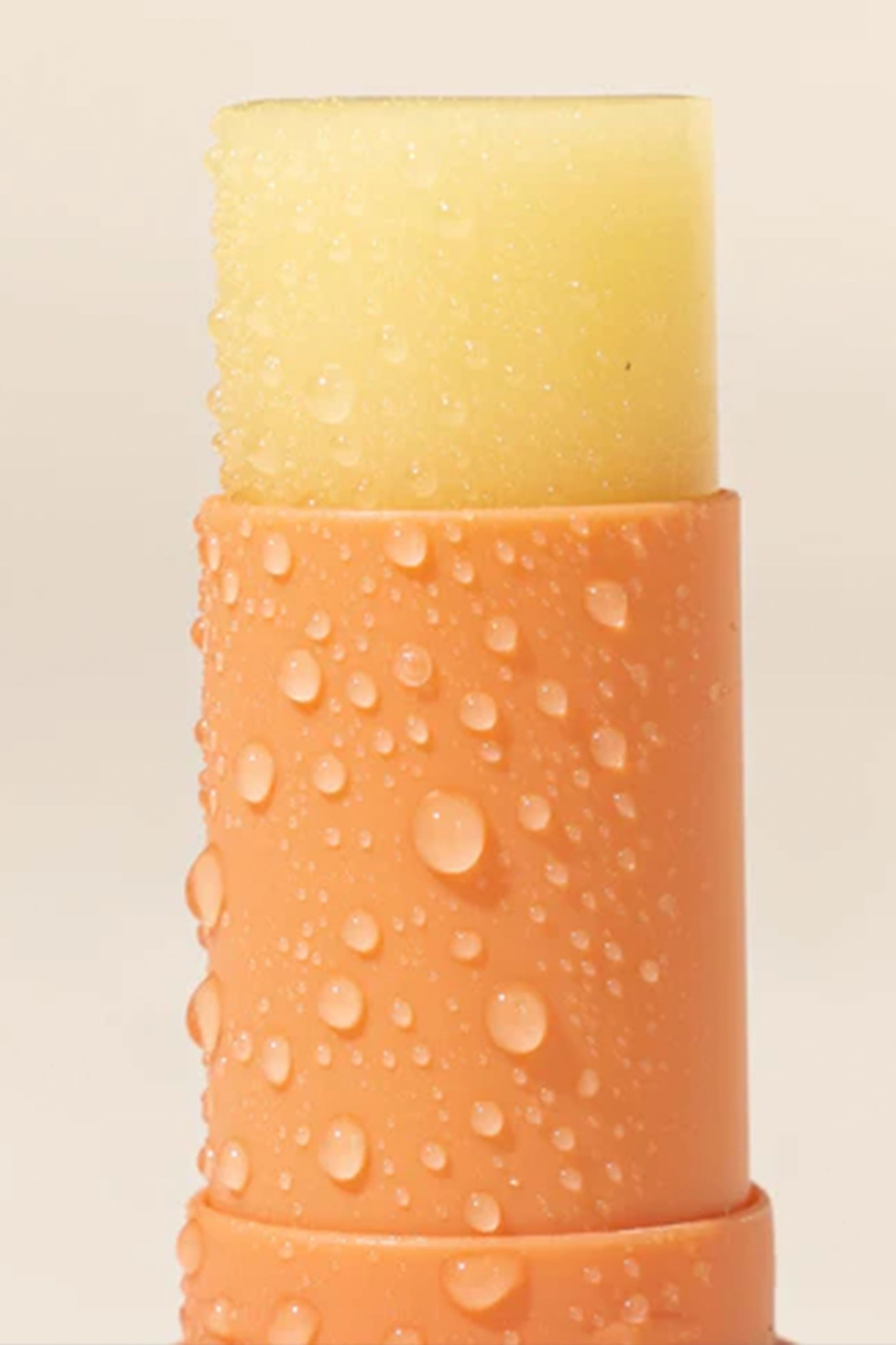 A 10ml orange tube of Other Sensitive Lip Balm SPF50+ with water droplets on its surface.